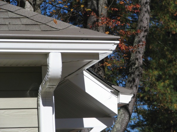 Corner of house with brown gutters.